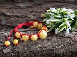 Amulet bracelet with red thread and light amber balls